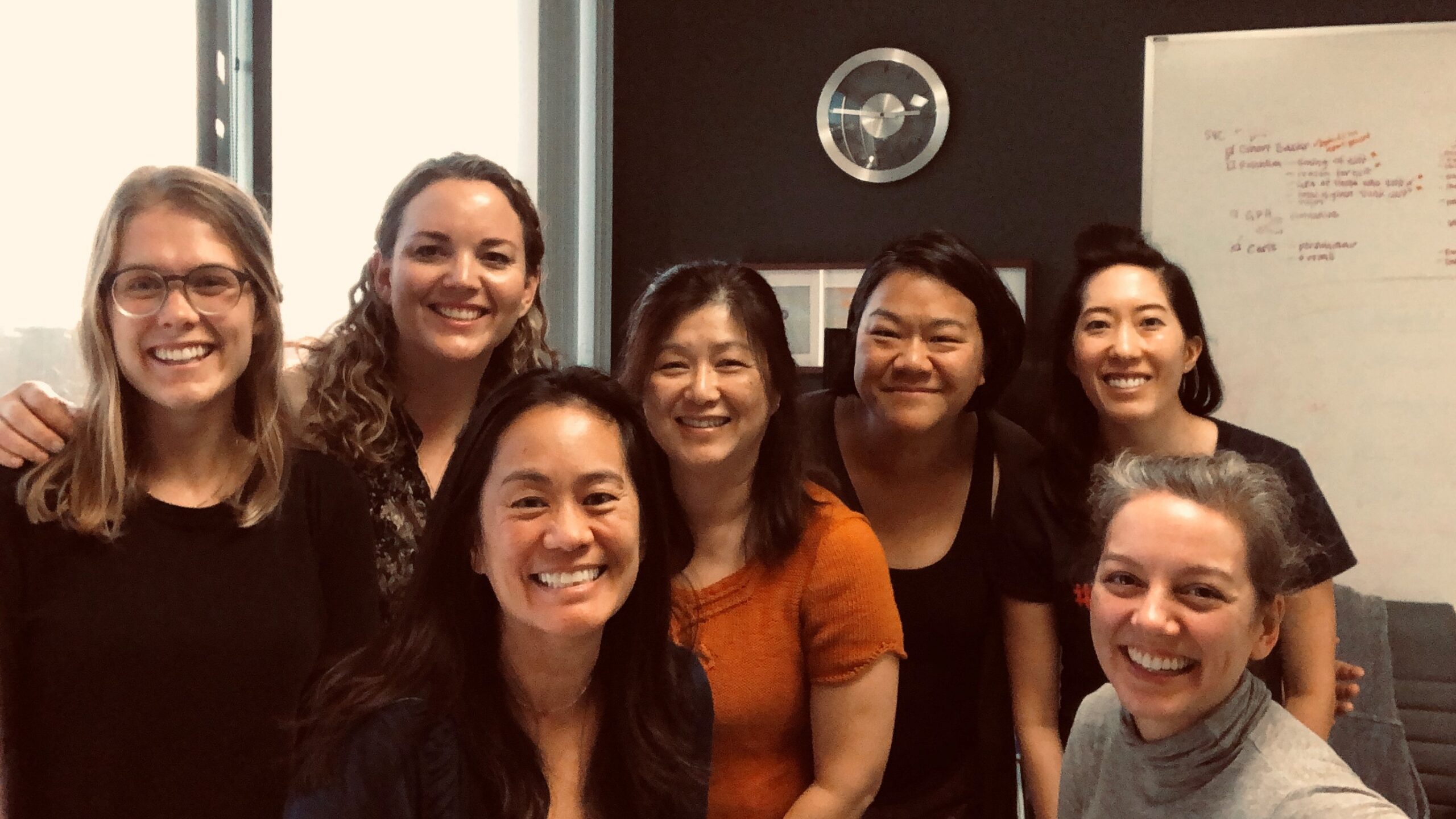 Seven women smiling in an office