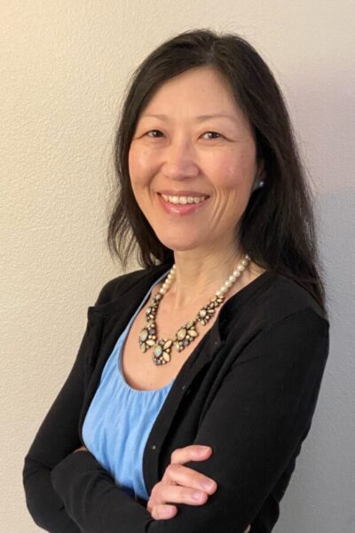 A middle-aged woman posing in professional clothing