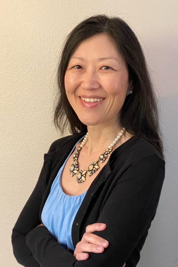 A middle-aged woman posing in professional clothing