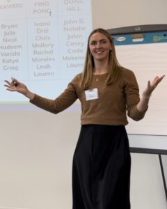 A woman presenting, holding her arms up