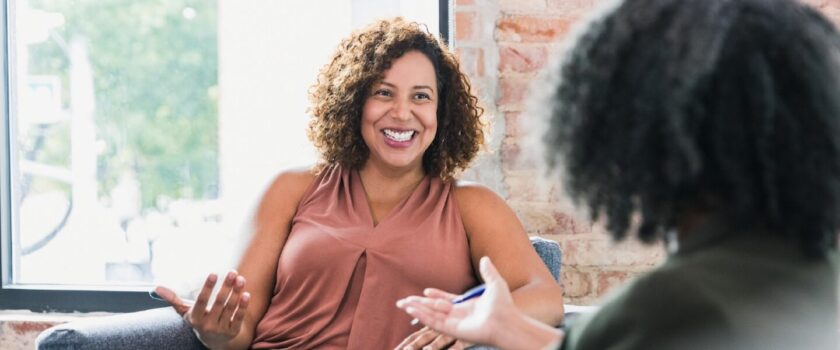 Photograph of a smiling woman having a conversation