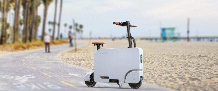 White Motocompacto electric scooter on road next to sandy beach
